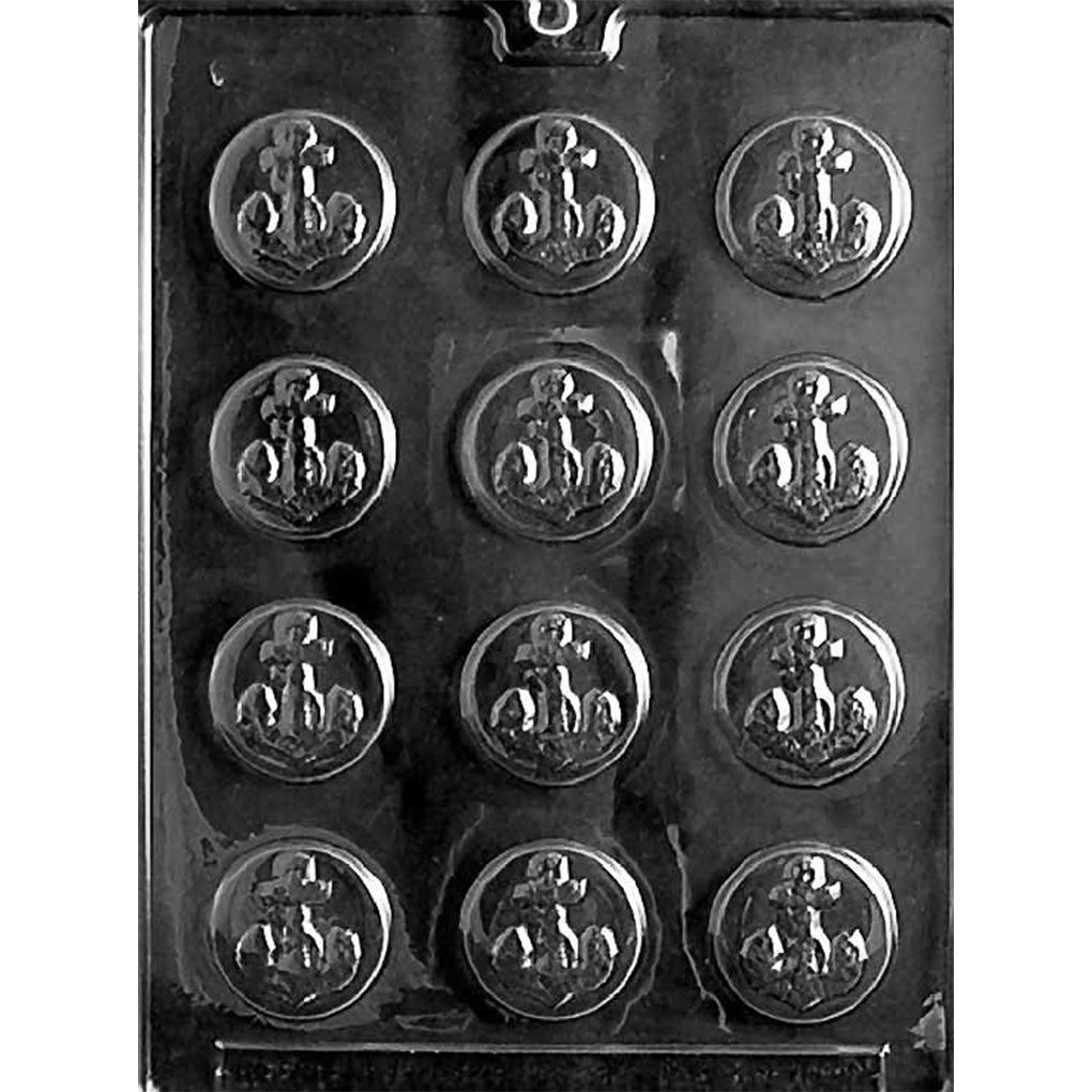 Clear plastic chocolate mold photographed on a dark background with twelve round cavities, each featuring an embossed anchor design in the center.