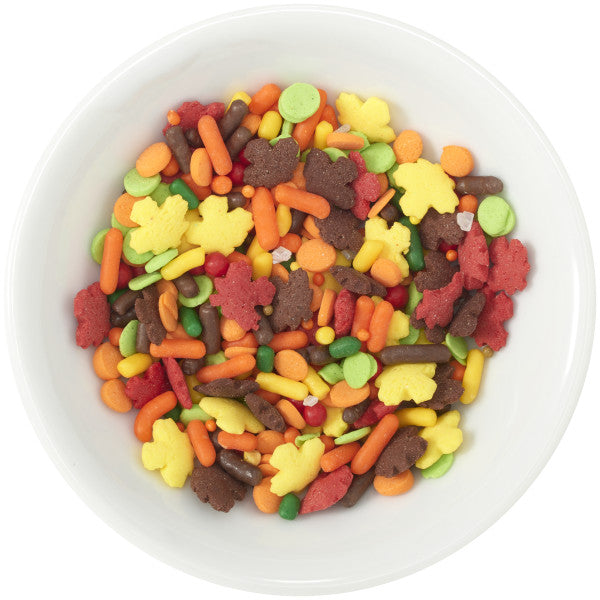 A colorful blend of autumn-themed sprinkles, including maple leaf quins in red, yellow, and brown, along with assorted sprinkles and pearls.