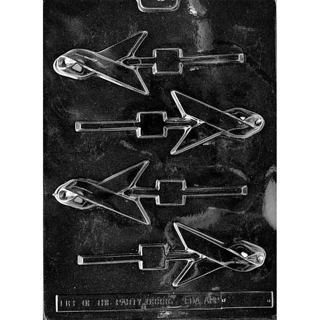 Clear plastic chocolate lollipop mold on dark background with multiple slim airplane-shaped cavities attached to stick channels, used for molded candy pops.