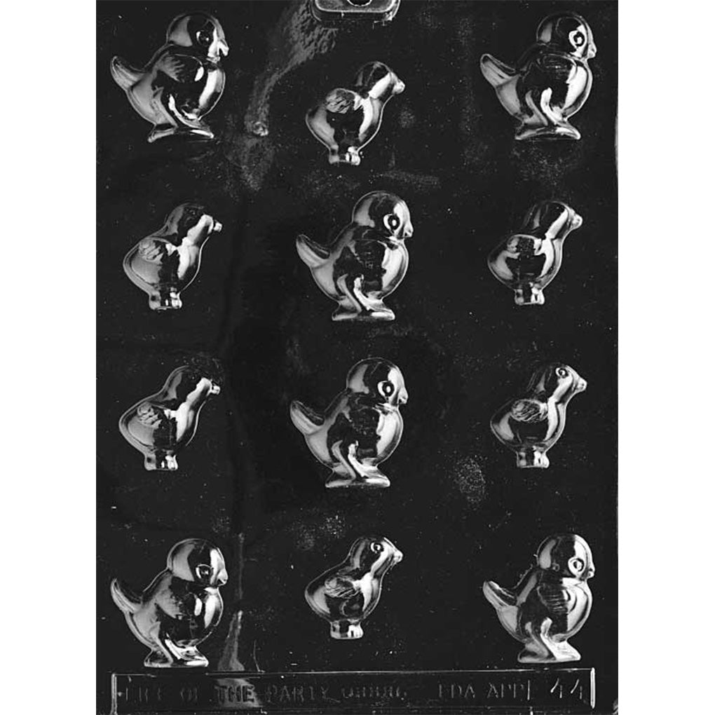 Clear plastic chocolate mold with multiple small baby chick cavities in assorted poses, featuring raised eyes, beaks, and wing details on a dark background.