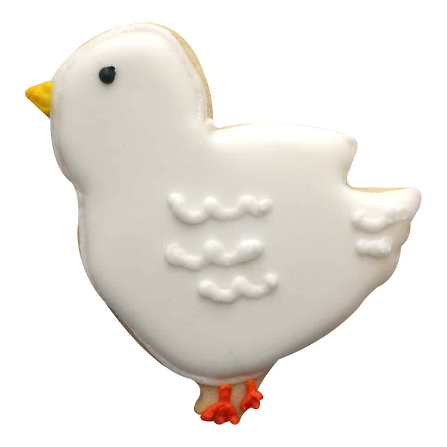 Decorated chick-shaped cookie with white icing, orange feet, and a yellow beak.