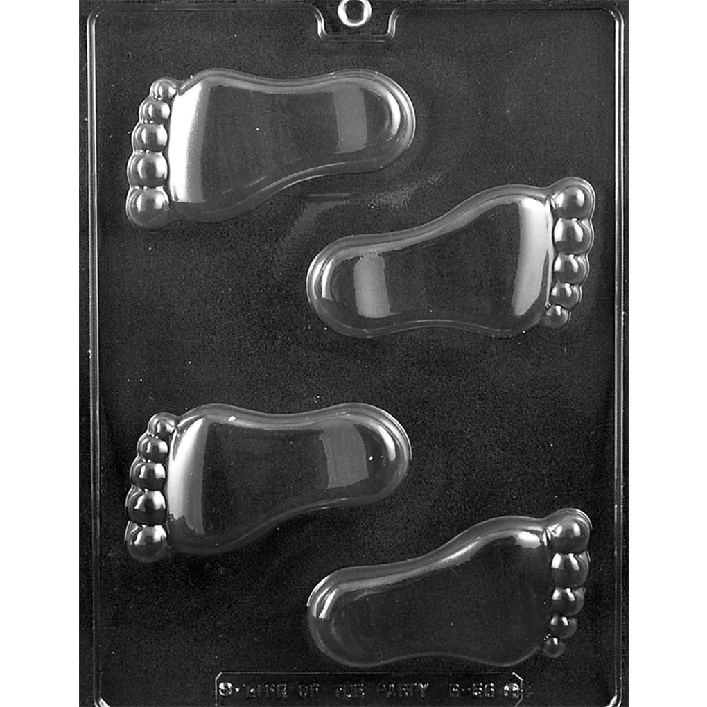 Clear plastic baby feet chocolate mold with four footprint cavities, shown against a black background.