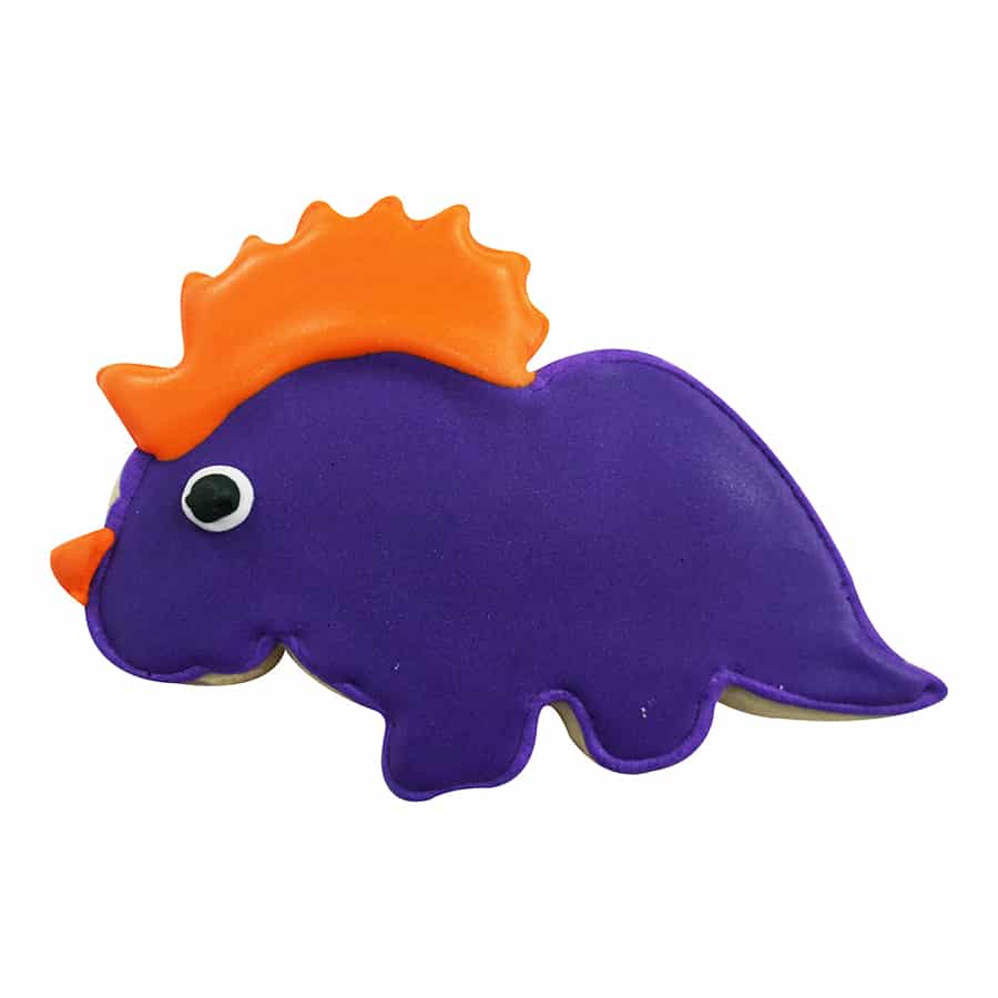 Decorated baby triceratops cookie with purple icing, an orange frill, and a black-and-white eye.