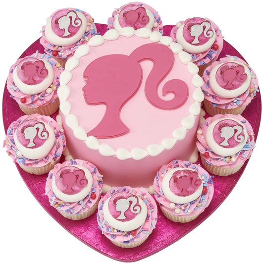 Pink cake surrounded by cupcakes, all topped with glittery pink Barbie silhouette rings and pastel sprinkles.