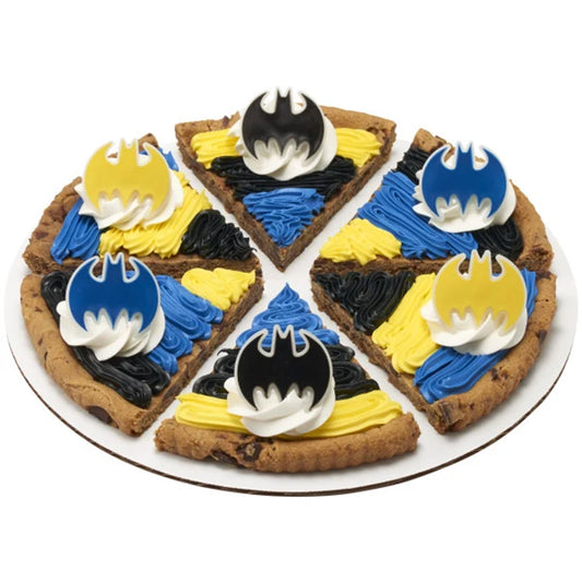Six triangular cookie cake slices decorated with black, blue, and yellow frosting and Batman bat emblem cupcake rings arranged on a round platter.