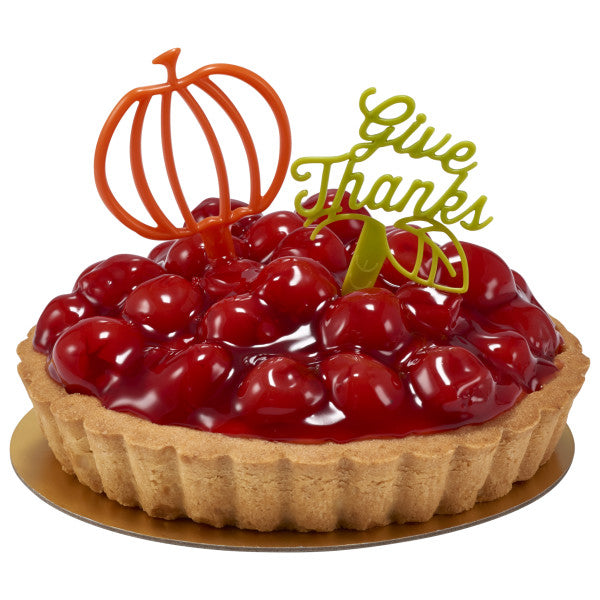 Cherry tart decorated with a green “Give Thanks” topper and an orange pumpkin accent pick.