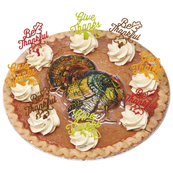 Pumpkin pie with whipped topping, decorated using multiple Thanksgiving picks and a colorful turkey cake image.