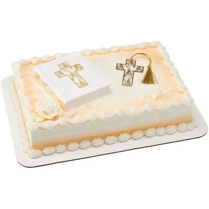 White Bible cake topper and gold cross bookmark arranged on an ivory sheet cake with piped borders and gold accents.