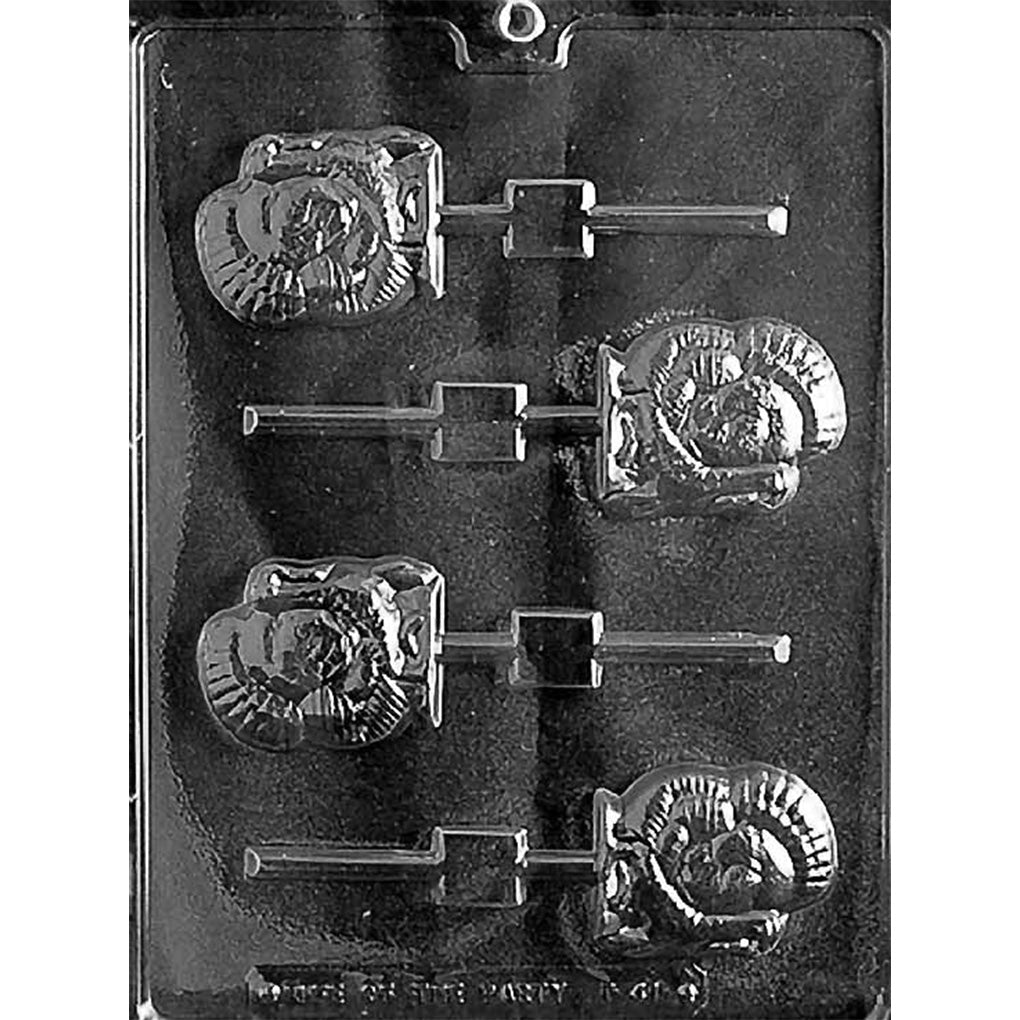 Clear plastic Tom turkey chocolate lollipop mold with four small turkey-shaped cavities featuring embossed feather fans and stick channels, on a dark background.