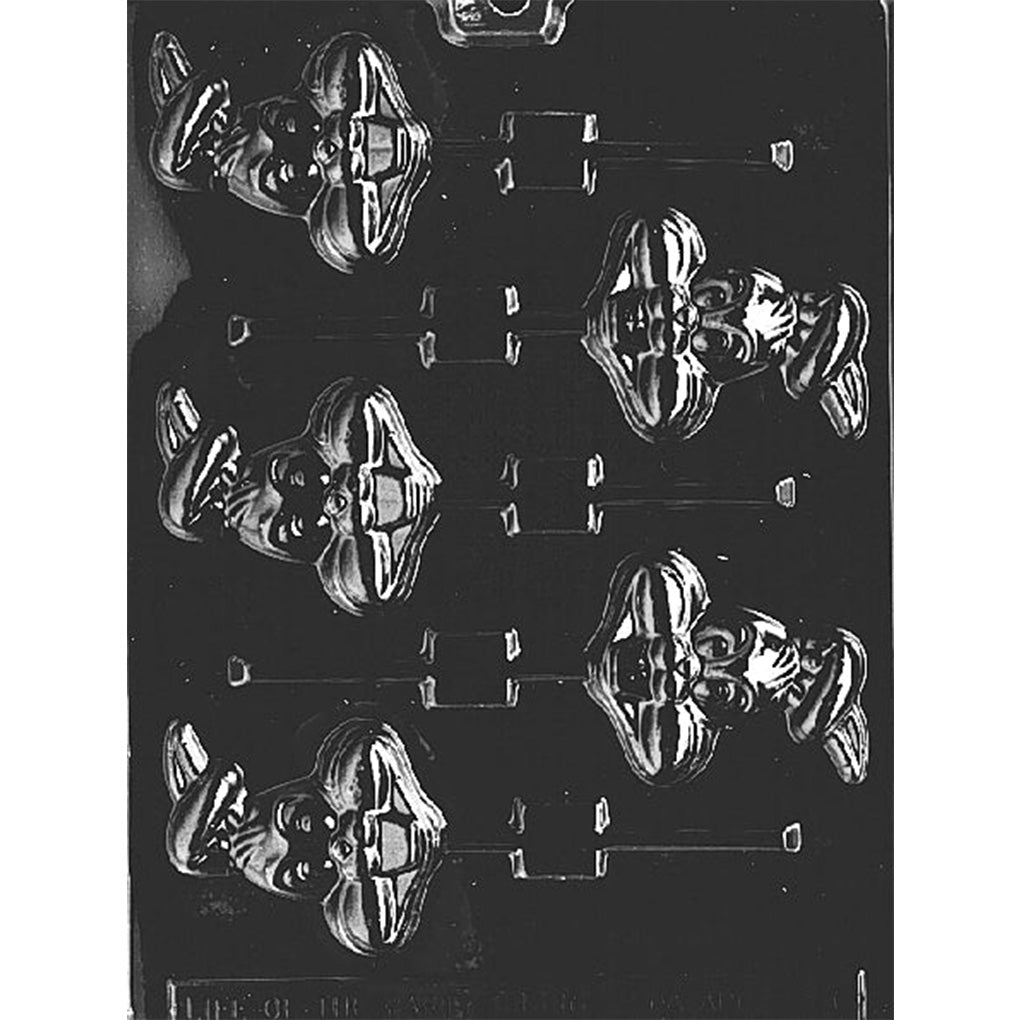 Clear plastic chocolate lollipop mold with bunny face cavities featuring crossed long ears over the head, raised eyes and cheeks, and built-in stick slots on a dark background.