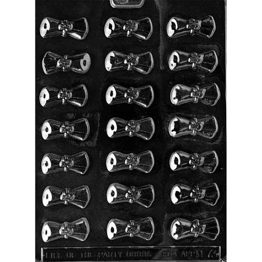 Clear plastic chocolate mold with eighteen small rolled diploma scroll cavities arranged in a grid, each with a tied ribbon detail in the center, on a dark background.