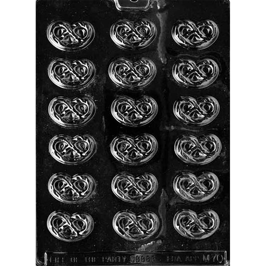 Clear plastic chocolate mold photographed on a black background with multiple pretzel-shaped cavities in rows, each cavity showing raised twisted pretzel lines.