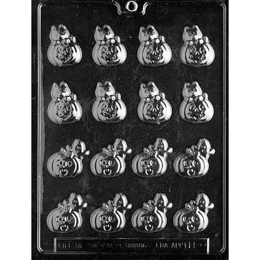 Clear plastic chocolate mold photographed on a dark background with sixteen small pumpkin-shaped cavities in two designs, one topped with a cat and one topped with a ghost.