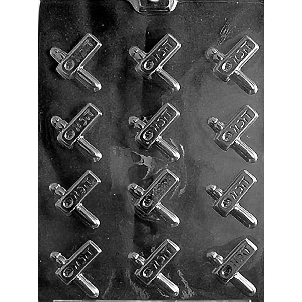 Clear plastic chocolate mold with 12 small Purim-themed cavities shaped like handheld noisemakers with a short handle and raised design details.