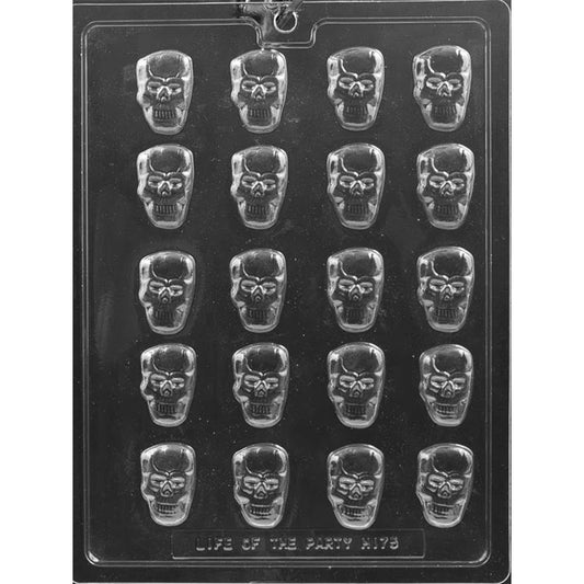 Clear plastic chocolate mold photographed on a dark background with multiple bite-size skull-shaped cavities arranged in rows, each showing eye sockets and a grinning teeth pattern.