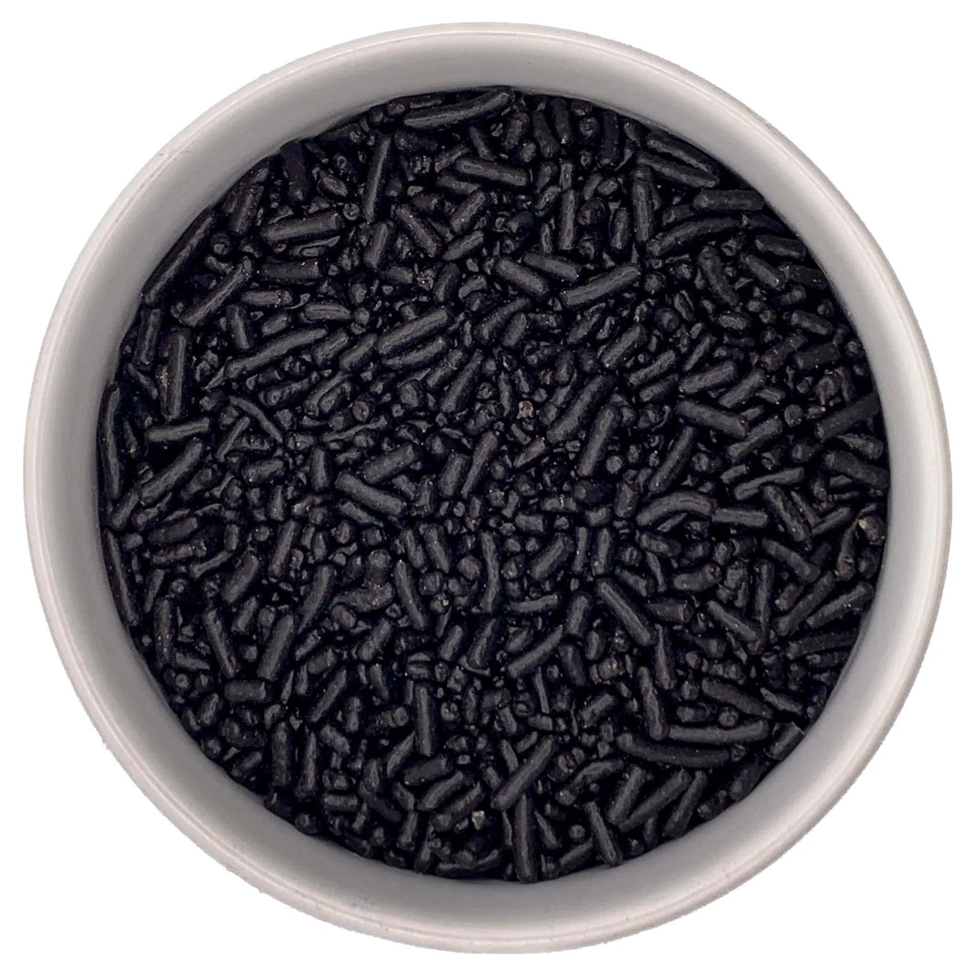 Overhead view of a white bowl filled with black jimmies sprinkles, showing small rod-shaped pieces and tiny bits clustered together.
