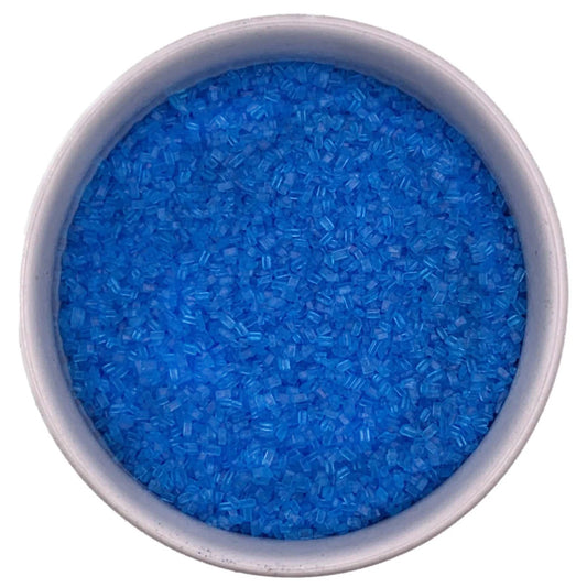 Top-down view of a white bowl filled with bright blue coarse sanding sugar crystals, showing chunky sparkling granules and a vivid ocean-blue color.