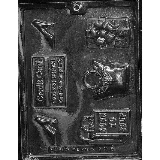 Clear plastic chocolate mold photographed on a dark background with assorted shopping-themed cavities including a high-heeled shoe, bow-topped gift box, credit card plaque, vintage handbag, and a shopping bag that says “BORN TO SHOP.”
