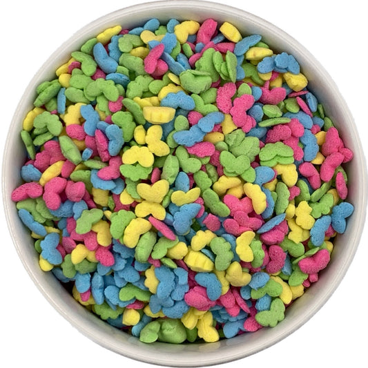 Bright butterfly-shaped quin sprinkles in pink, yellow, green, and blue colors, shown in a white bowl. Perfect for decorating cupcakes, cookies, and cakes.
