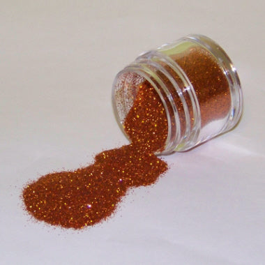 Orange copper-toned Galaxy Glitter Dust spilling from a jar, glistening with rich autumnal shimmer and golden flecks.