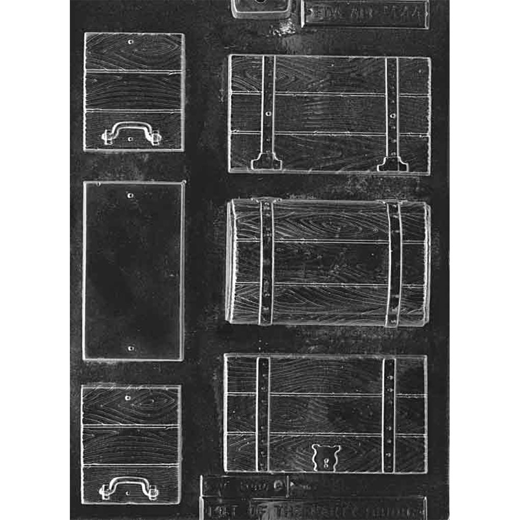 Clear plastic build-a-treasure-chest chocolate mold showing multiple panel cavities with wood plank texture, strap details, and handle/lock pieces for assembling a 3D chest.