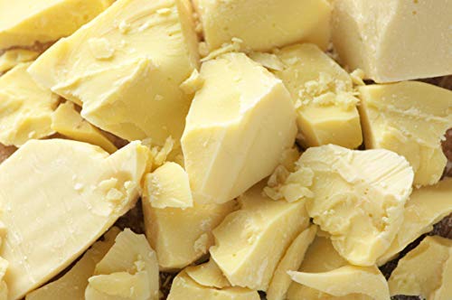 Close-up of chopped chunks of creamy coca butter, highlighting their rough texture.