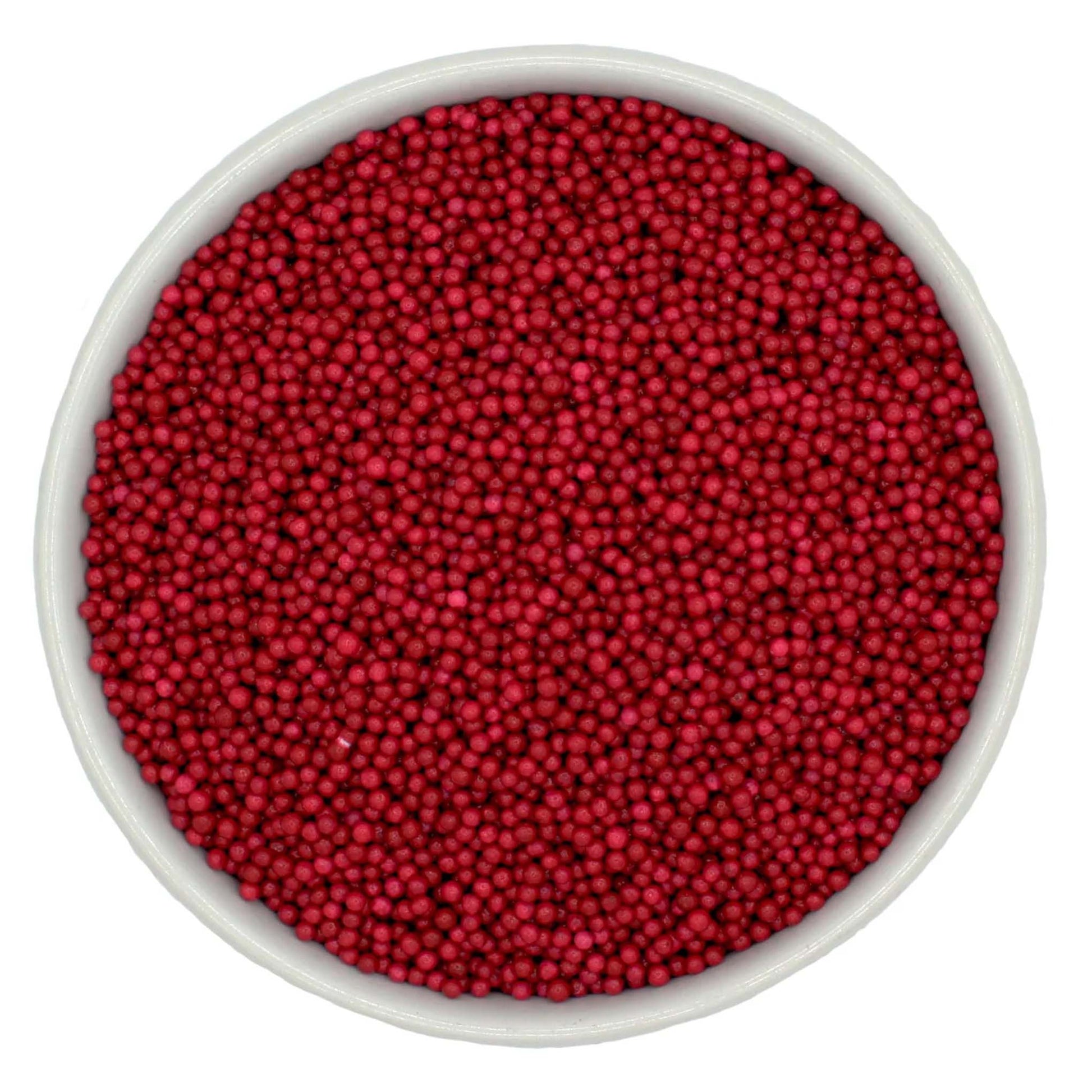 Bowl of burgundy nonpareil sprinkles on a white background.