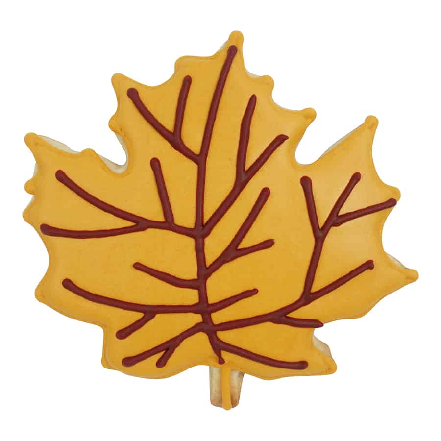 A decorated maple leaf cookie with golden-yellow icing and brown piped veins, resembling a fall leaf.