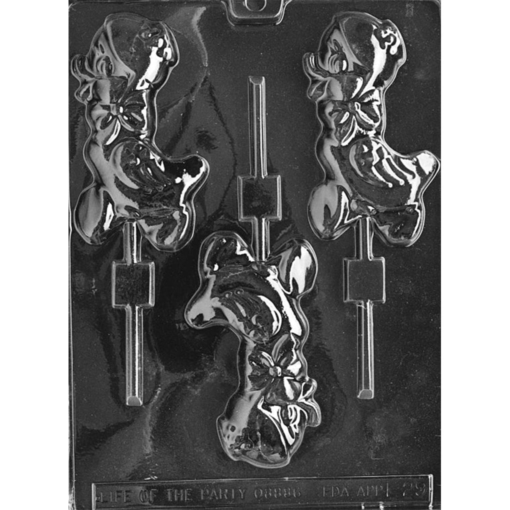 Clear plastic chocolate lollipop mold with three large cartoon duckling cavities, each showing a duck wearing a hat and neck bow, with built-in stick slots on a dark background.
