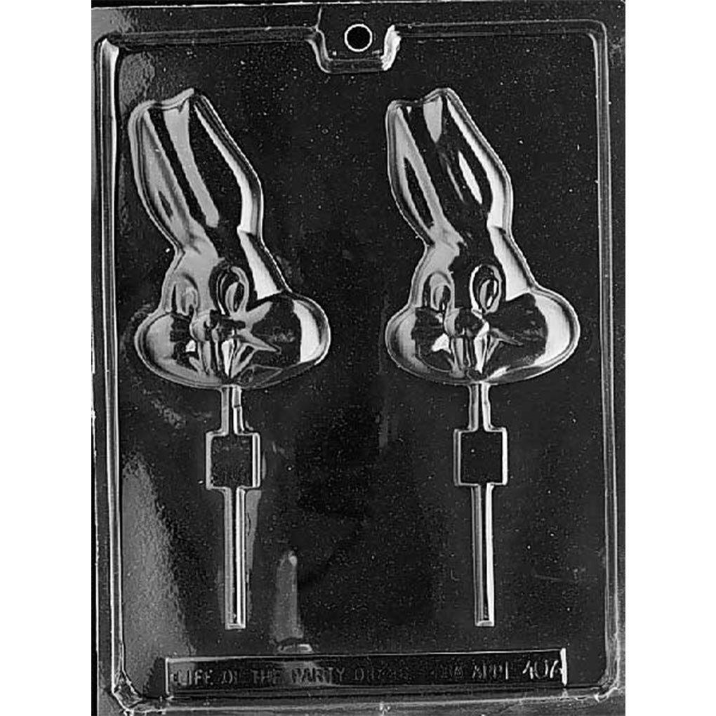 Plastic chocolate lollipop mold featuring two large cartoon bunny head cavities with exaggerated ears and prominent front teeth. Designed for creating chocolate pops for parties or holiday treats.