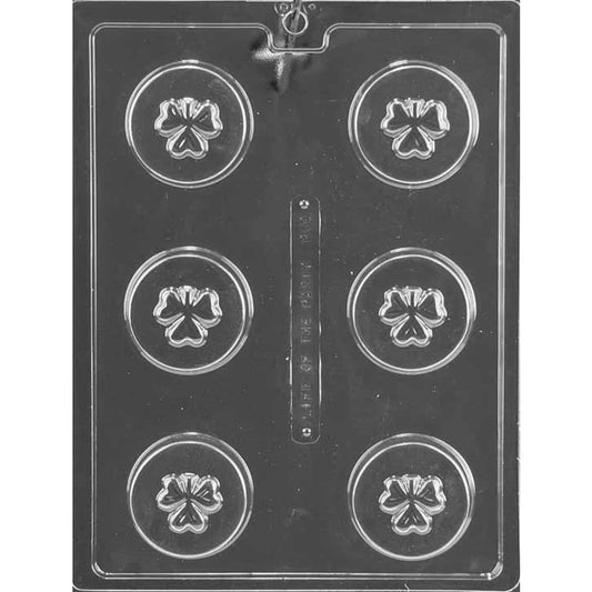 Shamrock cookie chocolate mold with six round cookie-sized cavities, each featuring a raised shamrock design in the center, shown in clear plastic.