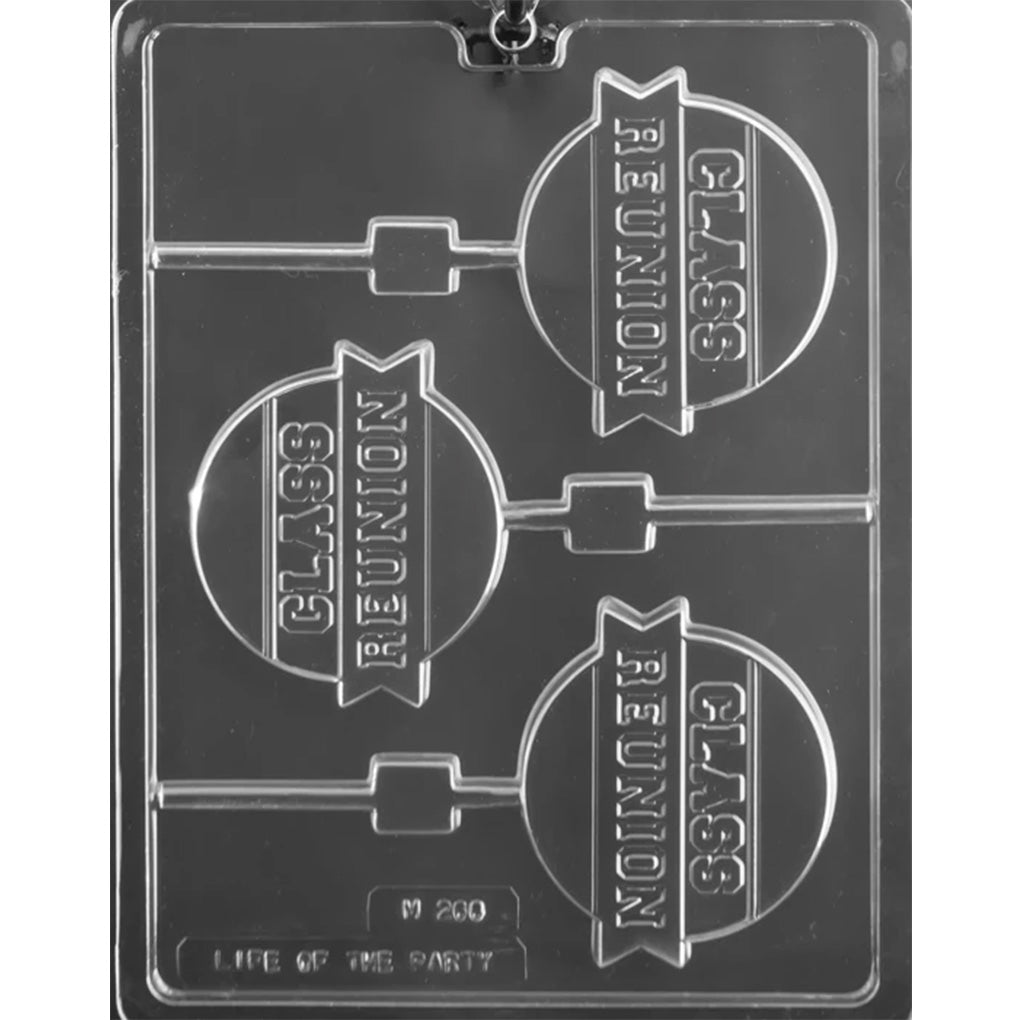 Clear plastic chocolate lollipop mold with three round cavities embossed with “Class Reunion” on a ribbon banner, each with a stick channel, shown on a dark background.