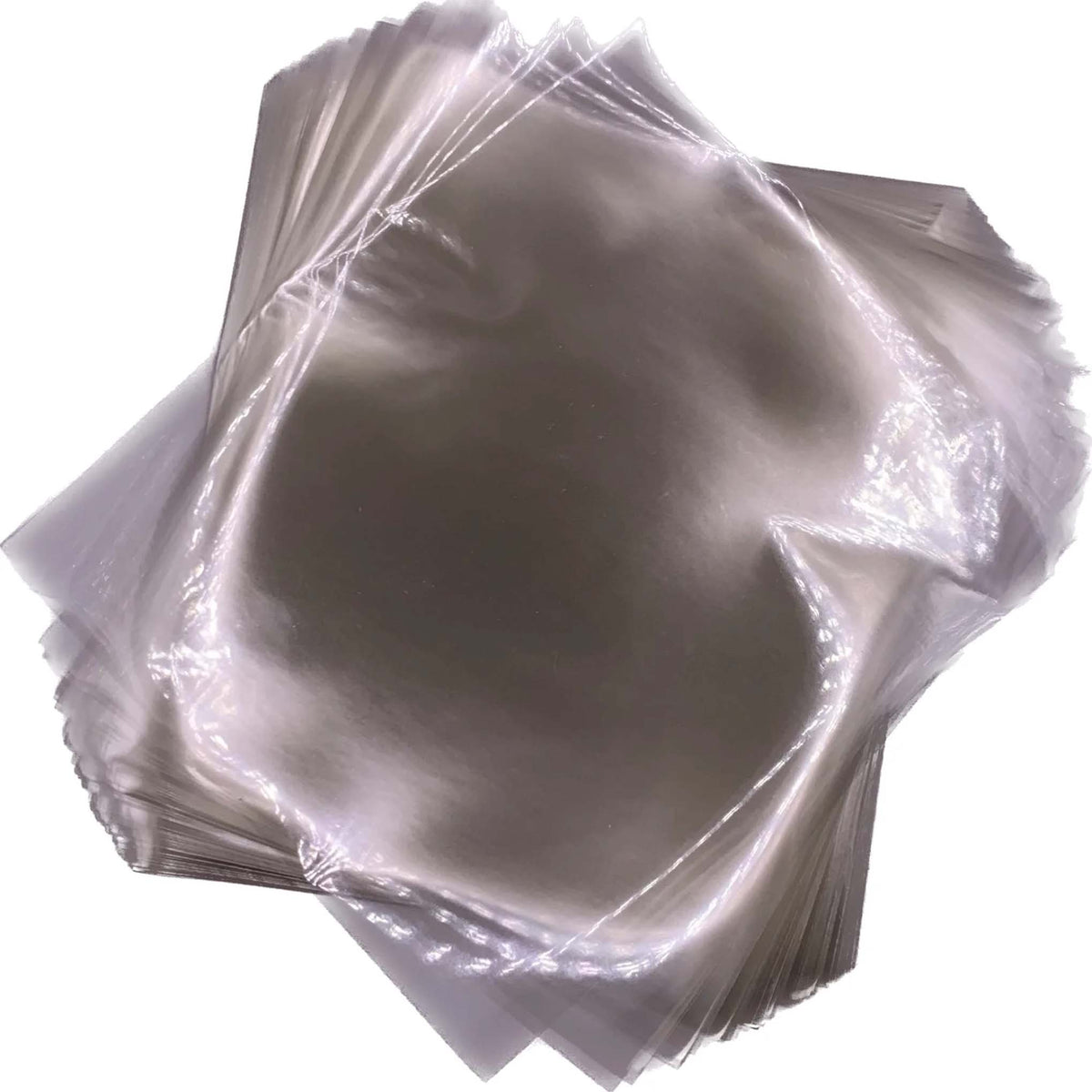 Overlapping stack of clear 4" x 4 ½" cellophane caramel wrappers with smooth, glossy surfaces.