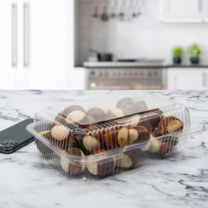 Clear hinged deli container with ribbed sides sitting on a kitchen counter filled with pretzel bites
