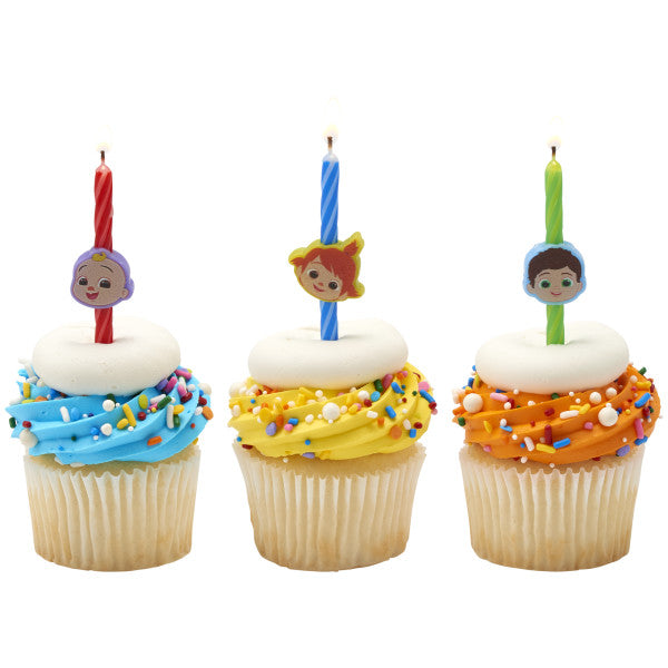 Three cupcakes decorated with colorful frosting and sprinkles, each topped with a CoComelon birthday candle featuring JJ, Nico, or TomTom character topper.