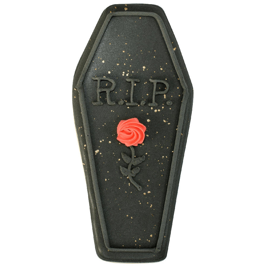 Black coffin cookie with 'RIP' and a red icing rose detail.