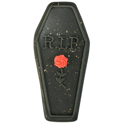 Black coffin cookie with 'RIP' and a red icing rose detail.