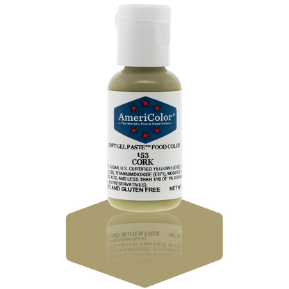  A bottle of AmeriColor Cork soft gel paste food coloring with a white cap, blue label, and red stars, positioned on a cork-colored reflective surface with the bottle’s reflection clearly visible.