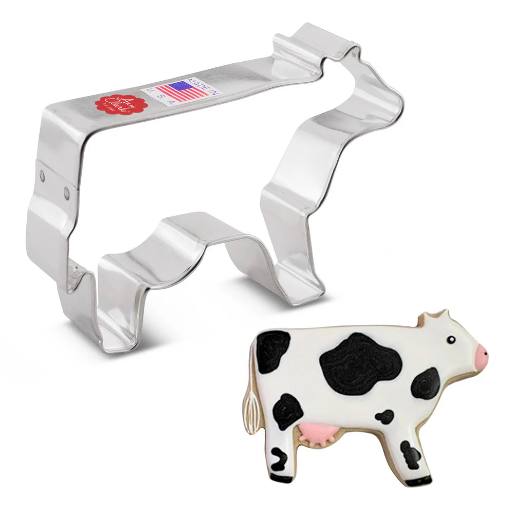 Cow Cookie Cutter alongside a decorated cow-shaped sugar cookie with white icing, black spots, and pink details.