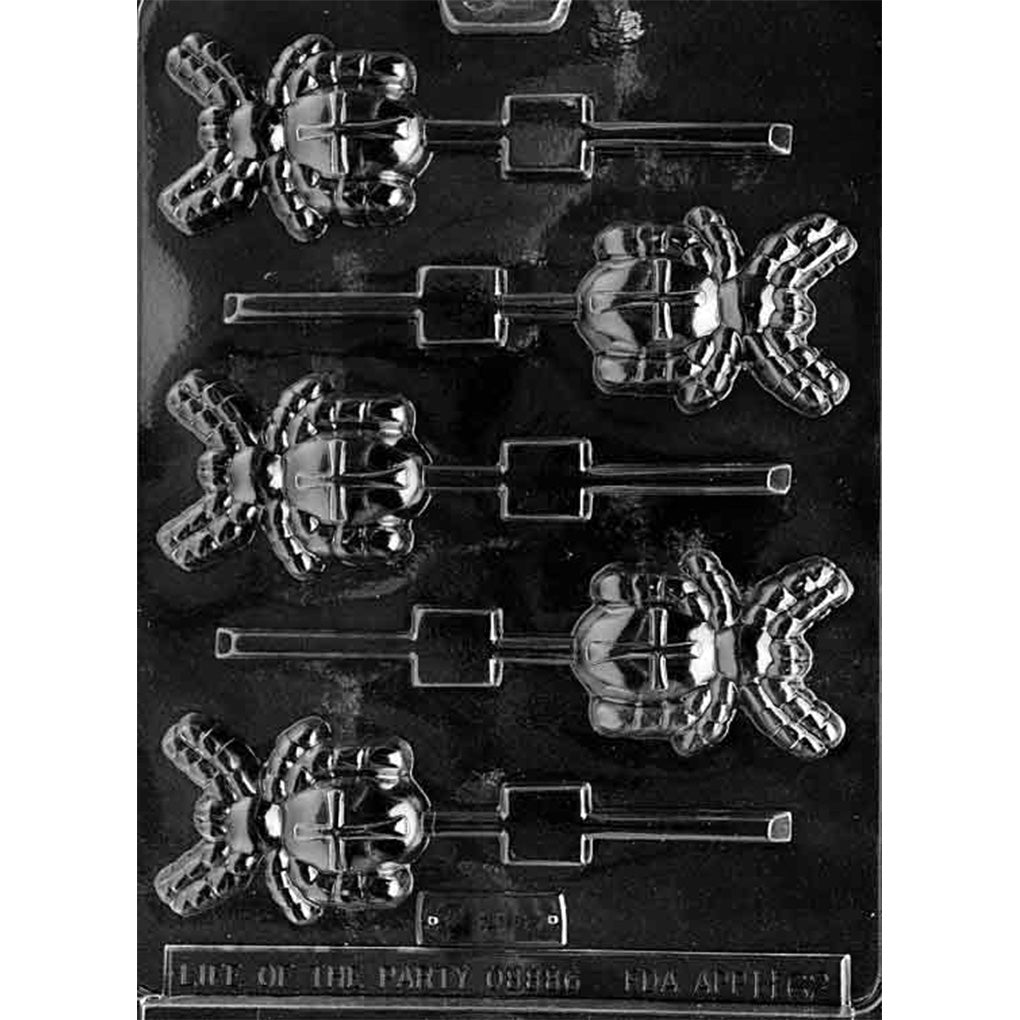 Clear plastic chocolate lollipop mold with spider-shaped cavities, each showing a rounded spider body, long legs, and a cross pattern detail on the back, on a dark background.