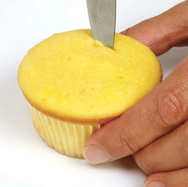 Cutting into cupcake top to prepare for filling.
