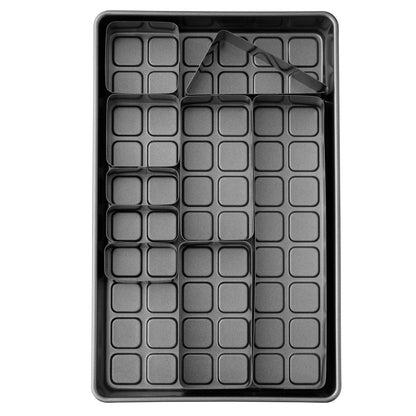 Top-down view of cake pan with metal inserts in place over a gridded base, set for baking letter or number cakes.