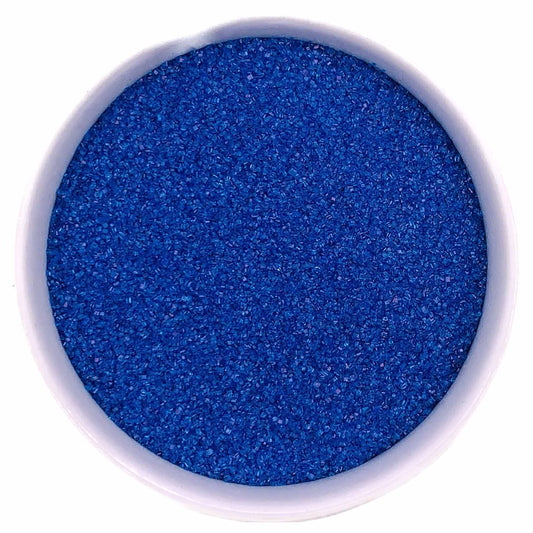 Bowl of dark blue fine sanding sugar crystals in a white container on a white background.