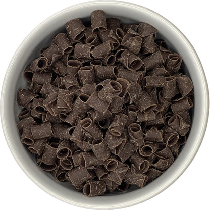 Bowl filled with dark chocolate curls, showing their rolled texture and rich chocolate color.