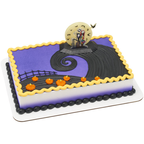 Purple and black sheet cake decorated with The Nightmare Before Christmas cake topper featuring Jack and Sally sitting in front of a yellow moon.
