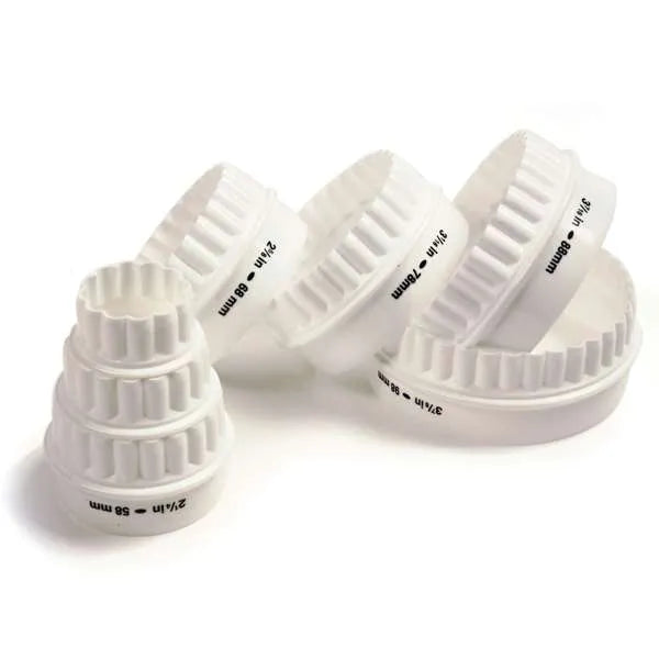 Set of white, round, fluted cookie cutters in various sizes.