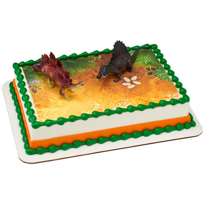 Sheet cake with green and orange border, printed prehistoric scene, and two dinosaur toppers.