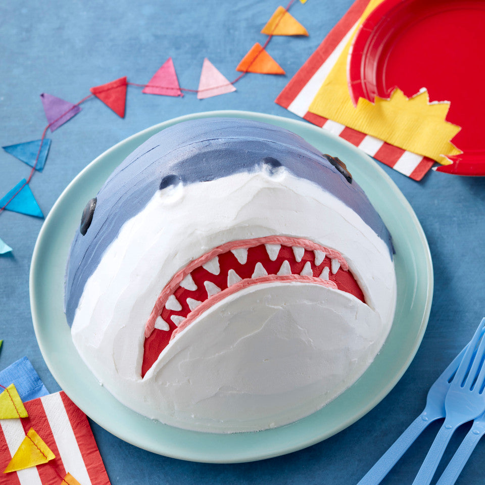 Dome-shaped shark cake with teeth and party decor, made using Wonder Mold Pan.