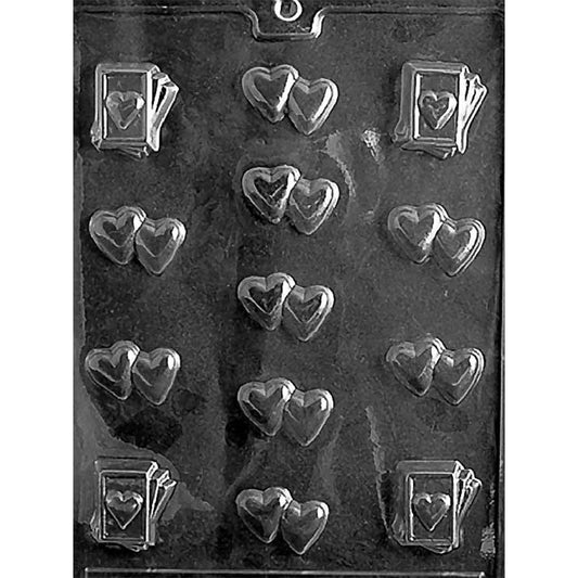 Clear Double Heart Assortment Chocolate Mold photographed against a black background with 12 cavities including paired heart designs and small heart-card chocolates.
