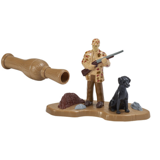 Close-up of plastic duck hunting cake topper set including a hunter figure with gun, black dog, and duck call.
